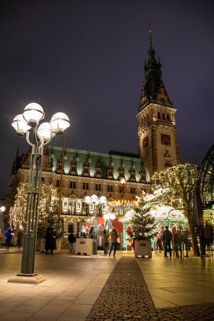 Evening scene at Hamburg Christmas market with festive lights and Town Hall backdrop.